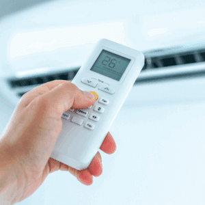 Main ajustant une télécommande blanche de climatisation. L'écran affiche la température '86°C', le mode 'AUTO', et des ondes. Boutons Temp, Fan, Options, Fav visibles.
